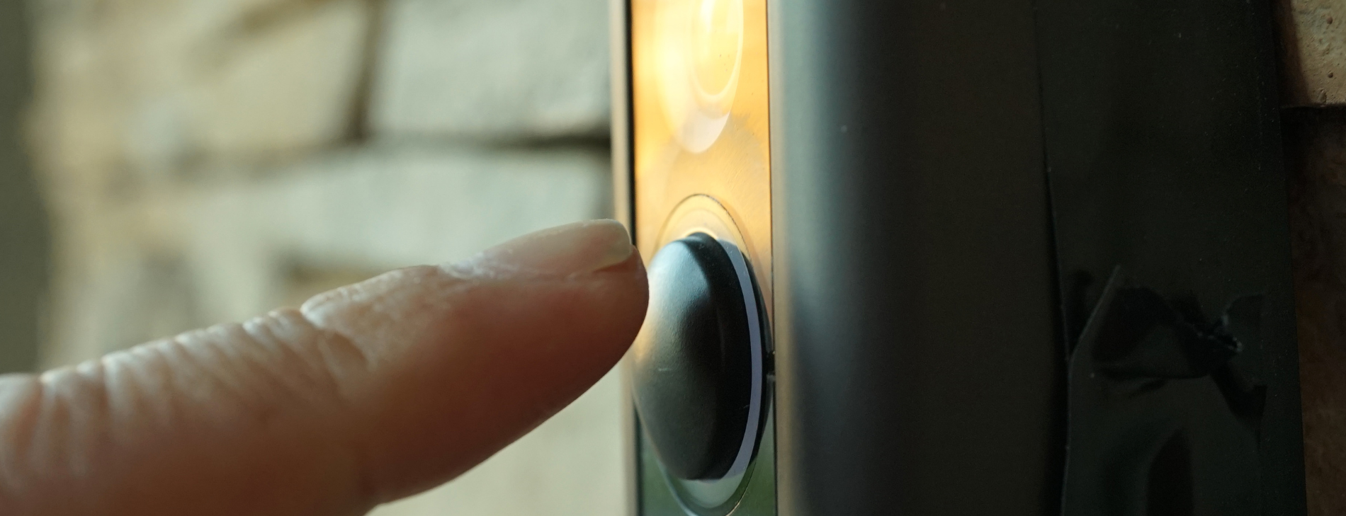 A finger pressing a doorbell camera